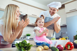 Eltern kochen gemeinsam mit einem Kleinein Kind (Kindersicheres Wohnen)