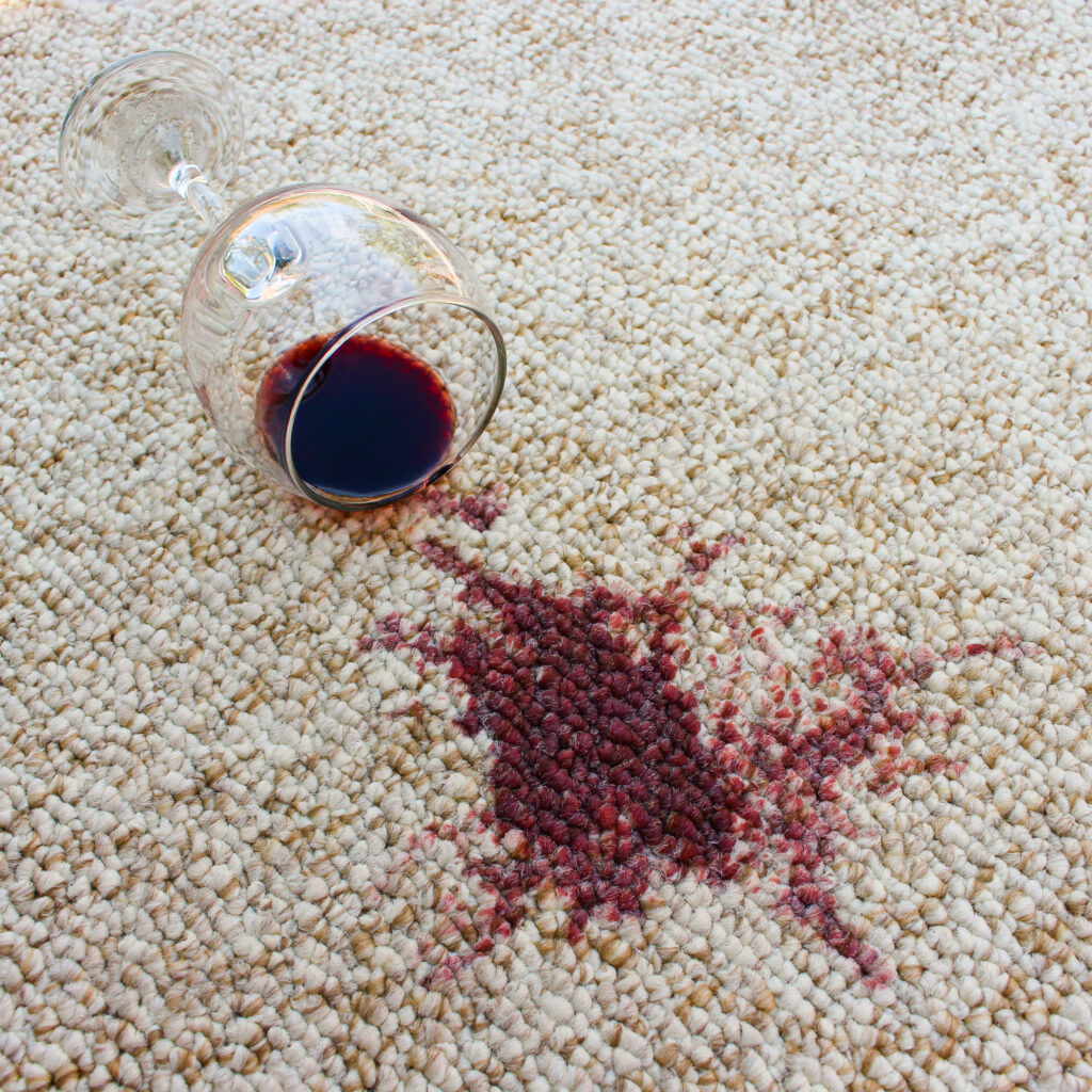 Ein ausgekipptes Rotweinglas auf einem Teppich