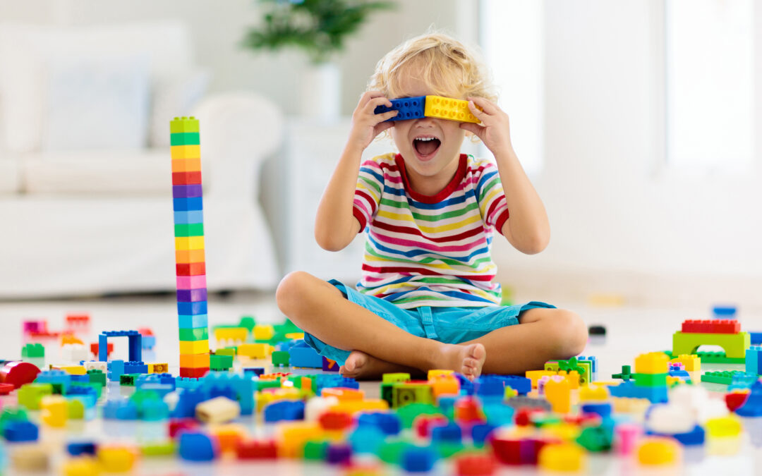 Kleiner Junge baut einen Turm aus Legosteinen